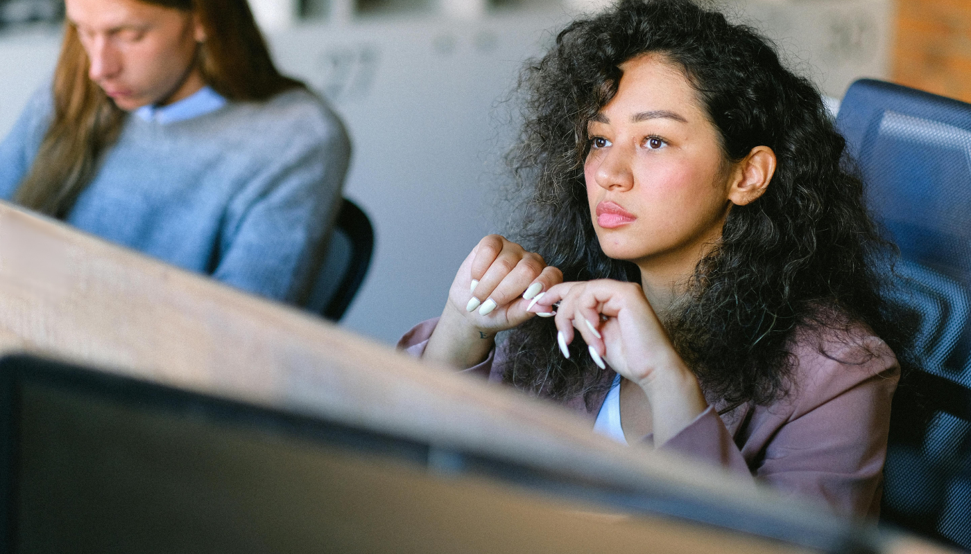 Woman sitting at her desk, deep in thought, noticing something feels off